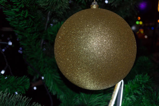 istock Christmas Bauble Coloured and Shiny on a Pine Tree in Winter Celebrations 1204330322