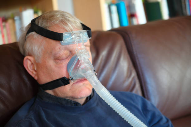 L’homme repose avec le dispositif de CPAP - Photo