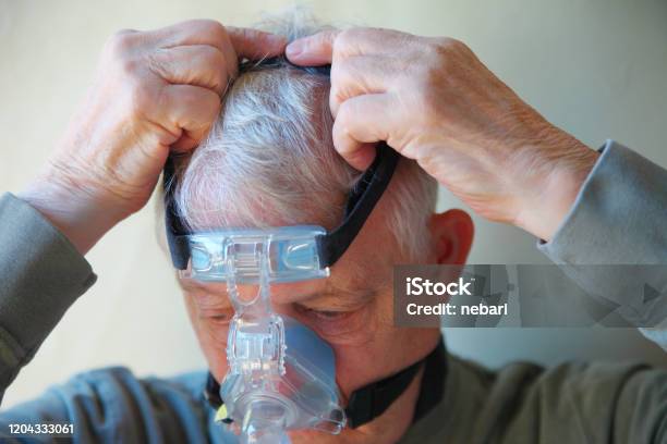 Older Man Puts On Cpap Device Head Gear Stock Photo - Download Image Now - Sleep Apnea, CPAP Machine, Senior Adult