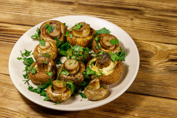 istock Baked mushrooms in plate on wooden table 1204334356