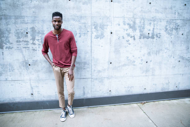istock Cheerful Black Male Standing by a Concrete Wall 1204334561