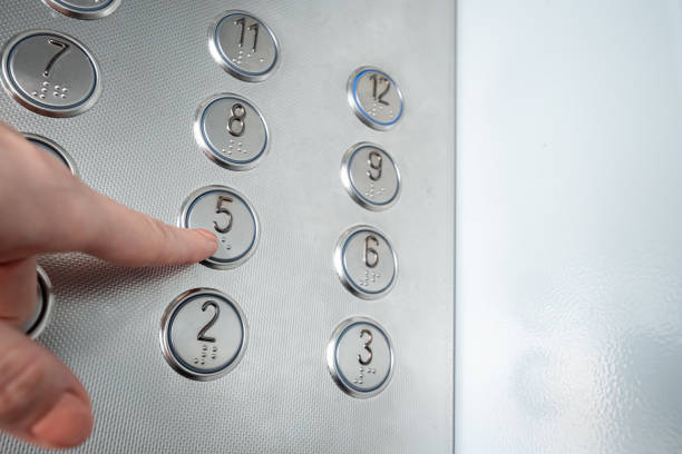 istock Female hand, finger presses the elevator button. up the career ladder. 1204335403