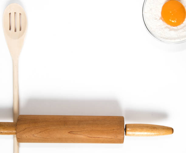 wooden spoons and rolling pin for baking and cooking with flower and egg yolk.  top view on white background - baking flour ingredient animal egg imagens e fotografias de stock