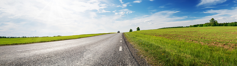 asphalt road panorama in countryside on sunny spring dayasphalt road panorama in countryside on sunny summer day. Empty highway landscape outdoors in nature with green grass and blue sky