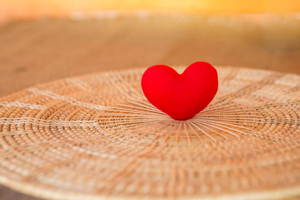Red heart on round rattan tray design, love and romance concept, valentine background idea