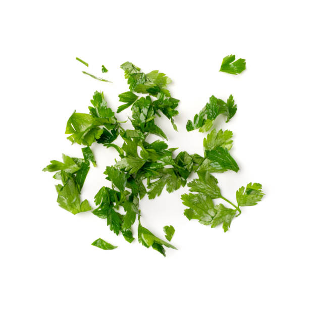 Fresh Green Chopped Parsley Leaves Isolated on White Background Fresh green chopped parsley leaves isolated on white background. Spicy aromatic sliced raw herbs of garden parsley. Cilantro or corriender leaves pieces top view cilantro stock pictures, royalty-free photos & images