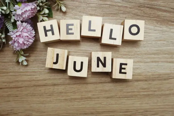 Photo of Hello June alphabet letters on wooden background