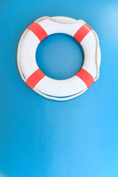 istock Bright Life Buoy in Blue background. Personal life support flotation safety device for swimmers, passengers or marine personnel working in area exposed to water. Drowning Protection Equipment concept. 1204354801