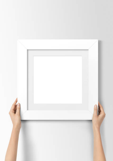 White blank photo frame Woman hands hanging white empty photo frame on wall pakistan photos stock pictures, royalty-free photos & images