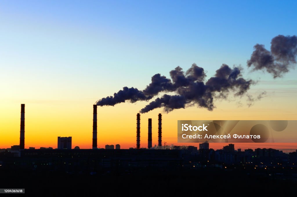 pipes smoke factories at sunset pipes smoke factories at sunset. the silhouettes of factories and Factory chimney blowing pollution in the environment. Smoking pipes of power plant on sunset. Coal Stock Photo