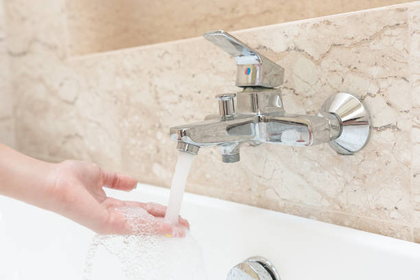 istock Woman hand taking a bath at home checking temperature touching water with hand. 1204363020