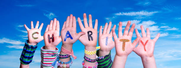 istock Children Hands Building Word Charity, Blue Sky 1204363434