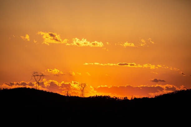 istock Orange sunset with silhouette moutain foreground and power line 1204367102