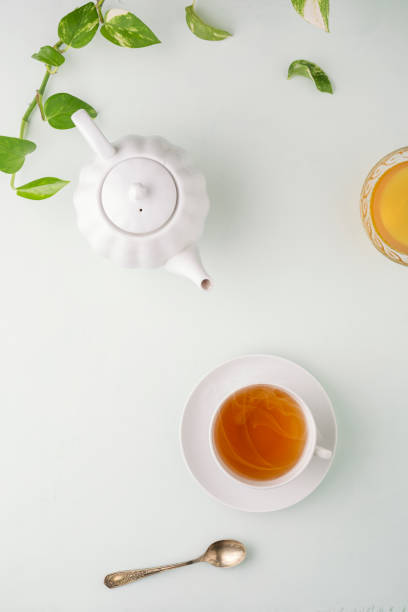 istock Fresh brewed tea, teapot and honey on a light table. White dishes. light background. Top view. 1204367243