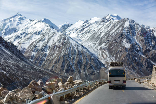 autobus turystyczny z scenerią pokrytych śniegiem ziem jesienią w drodze do przełęczy khunjerap, granicy pakistan-chiny, najwyższego przejścia granicznego na świecie, gilgit-baltistan, północny pakistan - west china zdjęcia i obrazy z banku zdjęć