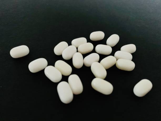 istock Pills or capsules candy on black background 1204368653