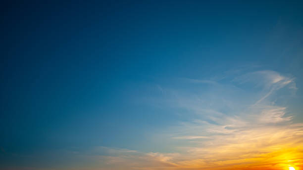istock Setting sun on a background of blue sky with clouds 1204369691