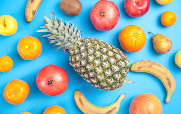 istock Pineapple, banana, pomegranate on a blue background. 1204371223