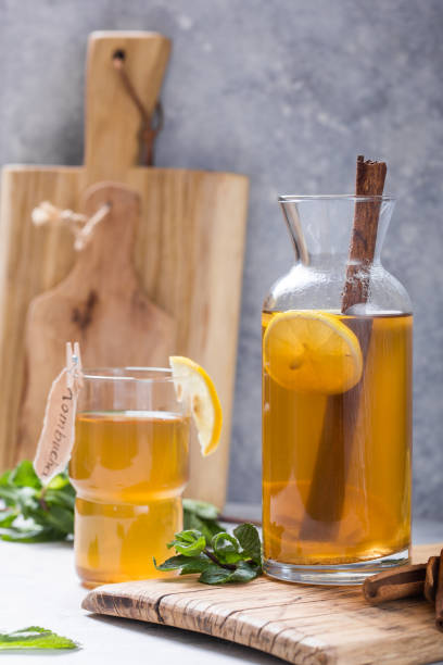 istock Kombucha or cider fermented drink. Cold tea beverage with beneficial bacteria, cinnamon, lemon on concrete  background side view with copyspace. For healthy nutrition. 1204371847