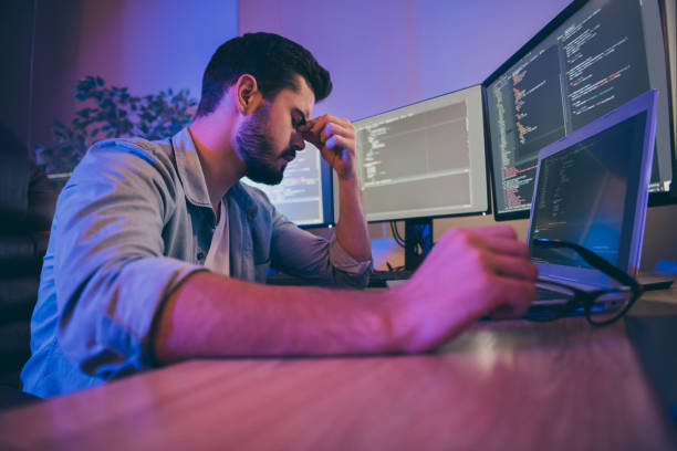 istock Profile side view portrait of his he nice attractive sad exhausted overworked guy feeling bad touching temples fail trouble shooting high tech content in dark room workplace station 1204373218