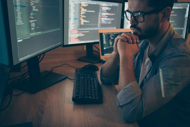 istock Close up photo of pensive serious interested programmer staring pensively into screen researching developing security software running into unknown critical error 1204374026