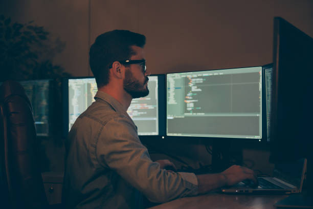 istock Profile side view of his he nice attractive focused serious skilled qualified brunet guy making outsource optimization hardware software display solution in dark beige room work place station 1204375554