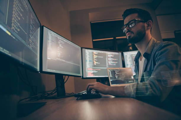 istock Profile side view of nice attractive serious skilled qualified smart clever bearded brunet guy nerd building fixing extracting file editing framework web design in dark beige room workplace station 1204375833