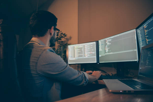istock Profile side view of his he nice qualified skilled focused brunette guy specialist testing web site database fixing bugs debug tracking optimization blockchain in dark beige room workplace station 1204376393