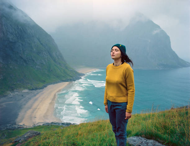 Young Caucasian woman looking at beach on Lofoten island, Norway
