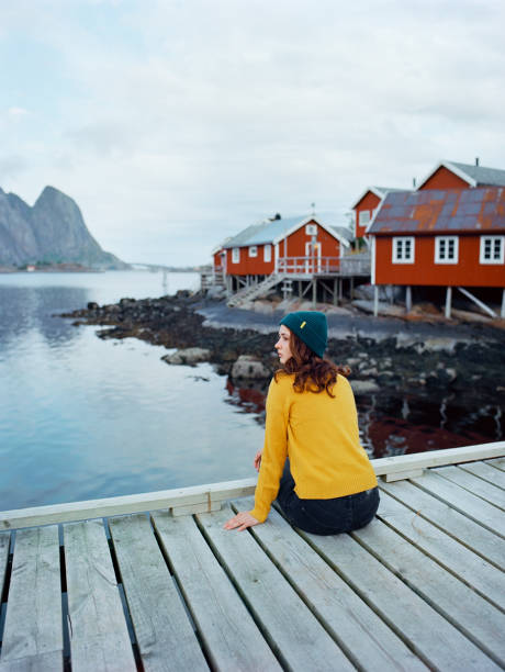 donna nel villaggio di reine nelle isole lofoten - fishing village nordic countries fjord foto e immagini stock