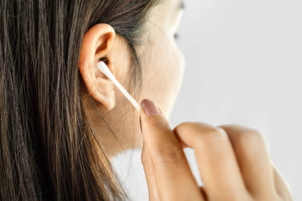 istock closeup woman hand clean her ear with cotton bud 1204379040