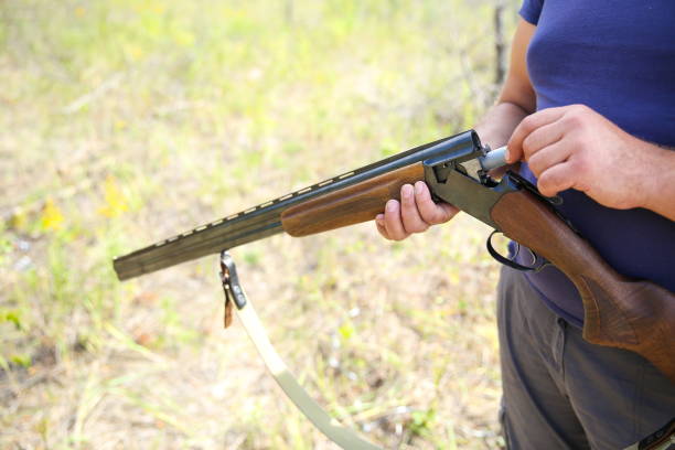 istock hunter holds a hunting rifle in forest 1204379428