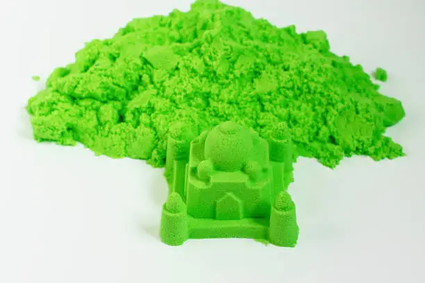 Photo of Kinetic sand of green color. Fine motor skills, creativity, games for children, entertainment