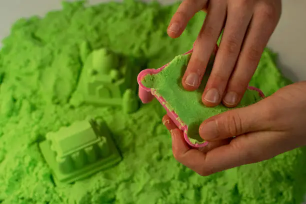 Photo of Kinetic sand. A child plays with kinetic sand. Fine motor skills, creativity, games