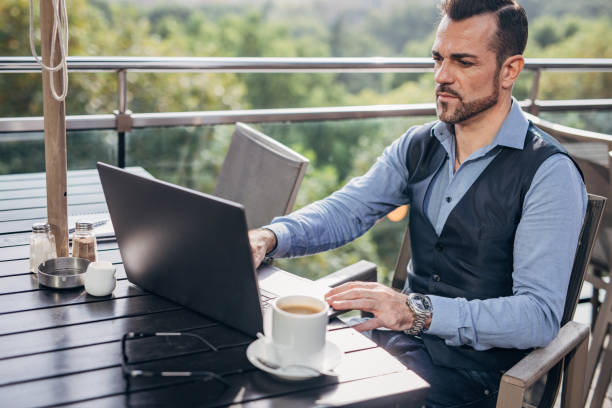 istock Handsome business man sitting on the restaurant terrace 1204381196