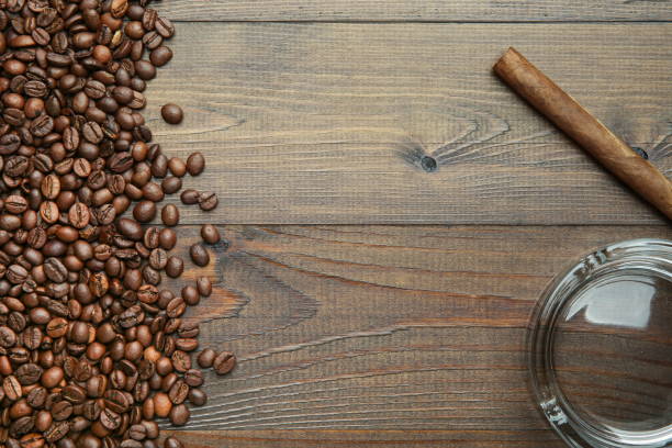 cigar, ashtray and coffee beans on wooden background flat lay with copy space