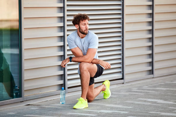 istock Young man exercising / stretching in urban area. 1204381560