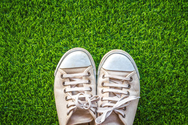 istock close up of white sneakers on green grass background 1204386897