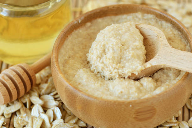 homemade honey and oatmeal face mask in wooden bowl with spoon - oat imagens e fotografias de stock
