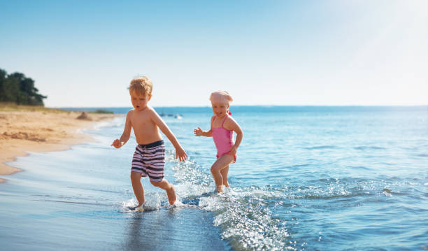 istock Boy and girl playing on the beach on summer holidays 1204390367