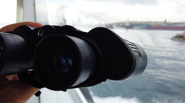 controlling sea with black binoculars controlling sea with black binoculars white sailboat silhouette stock pictures, royalty-free photos & images