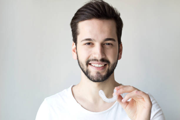 istock Close-up Of A Man's Hand Putting Transparent Aligner In Teeth 1204391867