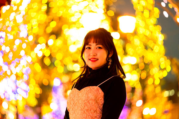 istock Young woman standing against illuminations background 1204392418