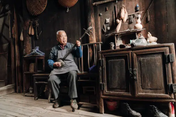 Chinese senior man playing longneck lute