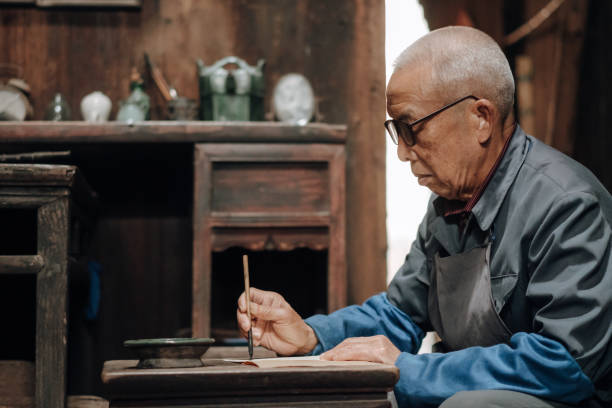 istock Chinese senior man writing chinese calligraphy 1204393249