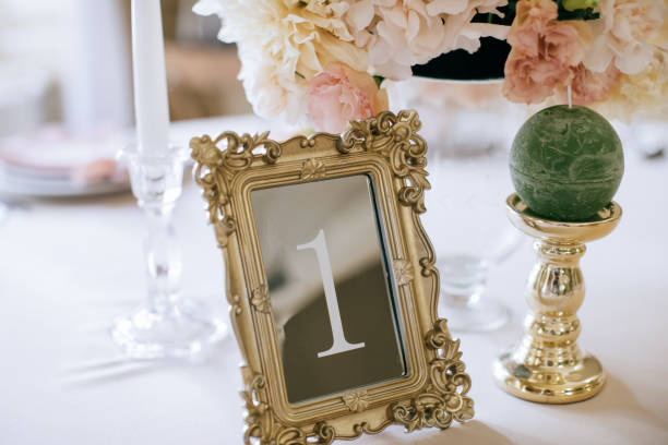 istock Vintage frame  with a table number in a restaurant at a wedding party. Beautiful wedding decoration 1204393392