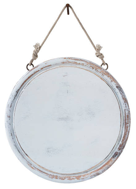 istock Old weathered worn white circular wooden board sign panel, hanging by old rope from an old rusty nail, isolated on white, clipping path included. 1204394371
