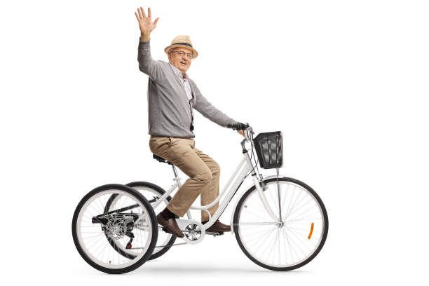 istock Senior man riding a tricycle and waving at the camera 1204394724
