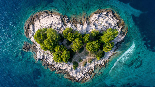 vista aérea da ilha em forma de coração. mar do oceano azul com onda e pequena floresta e litoral rochoso. - croatia nature tree plant - fotografias e filmes do acervo