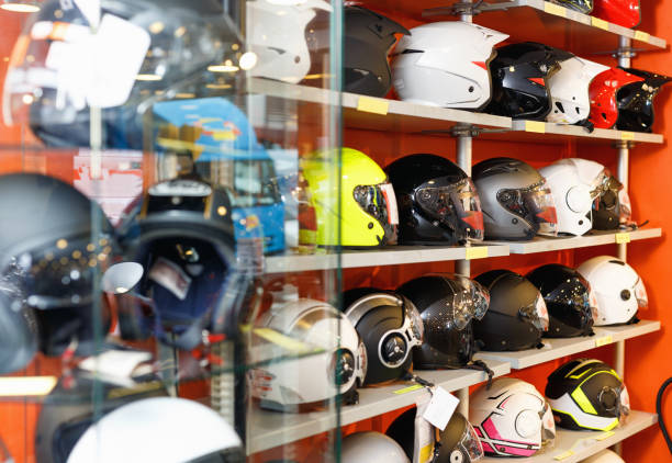 interior del salón de motos con cascos de moto coloridos en los estantes - extremal fotografías e imágenes de stock